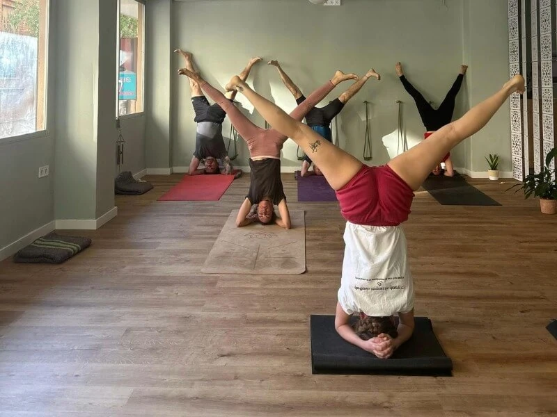 Persona practicando una postura de yoga de estiramiento lateral, con el brazo elevado y el cuerpo alineado; aparece una etiqueta con la palabra Avanzado.
